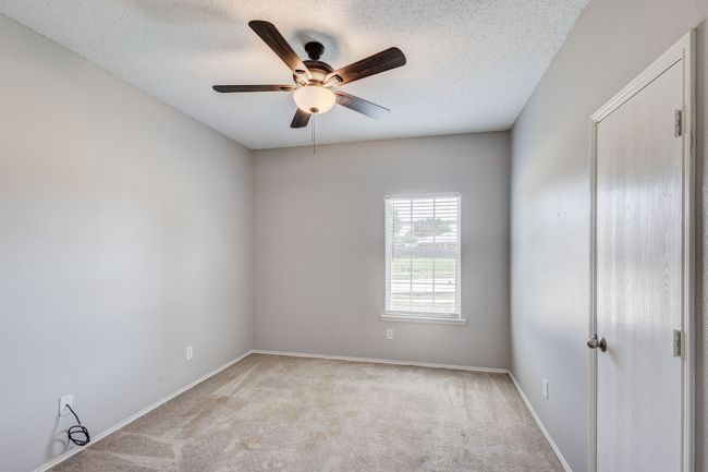 Unfurnished room with a ceiling fan, light carpet, baseboards, and a textured ceiling | Image 21