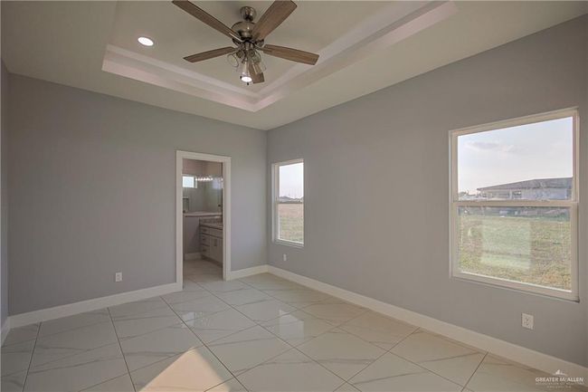 Spare room with a wealth of natural light, ceiling fan, and a tray ceiling | Image 17