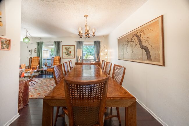 Dining space featuring a textured ceiling, a notable chandelier, and dark wood finished floors | Image 5