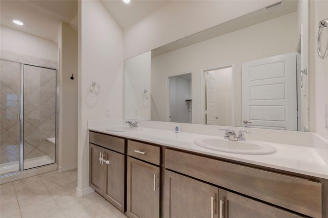 Bathroom featuring double vanity, a sink, a shower stall, and visible vents | Image 25