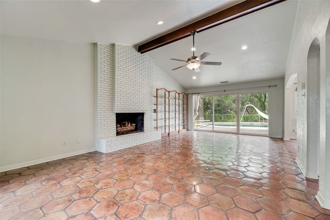 Unfurnished living room with a ceiling fan, a brick fireplace, baseboards, and recessed lighting | Image 7