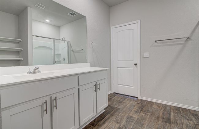 Full bath featuring vanity, baseboards, visible vents, a shower with shower door, and wood finished floors | Image 19