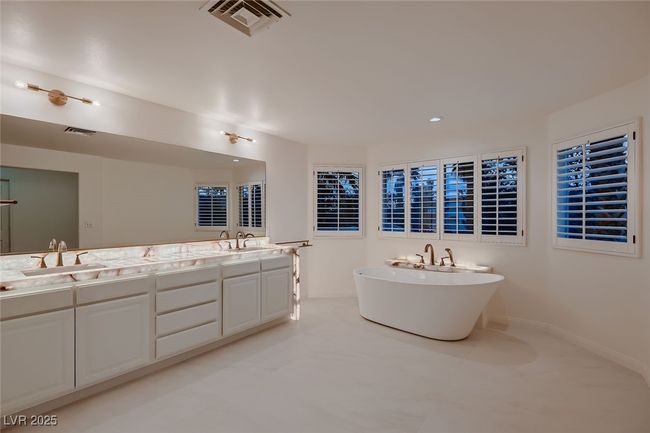 Bathroom featuring visible vents, a sink, a freestanding bath, and double vanity | Image 40