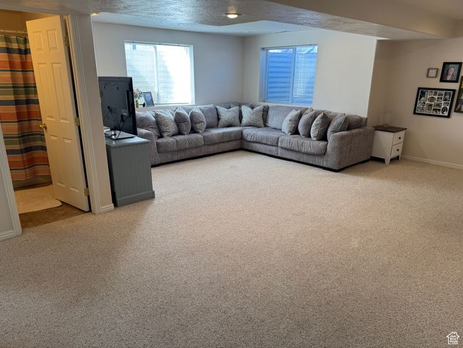 Carpeted living area with baseboards and a textured ceiling | Image 14