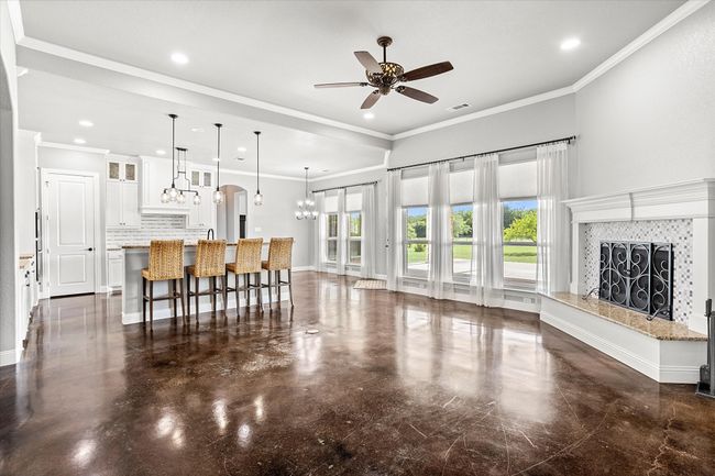 Living area with ceiling fan, a fireplace, a chandelier, recessed lighting, and crown molding | Image 10