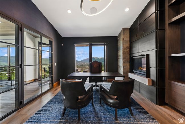 Dining area featuring light wood finished floors, a large fireplace, lofted ceiling, a mountain view, and recessed lighting | Image 109