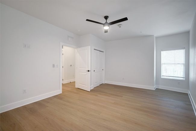 Unfurnished bedroom with light wood-style floors, baseboards, and ceiling fan | Image 9