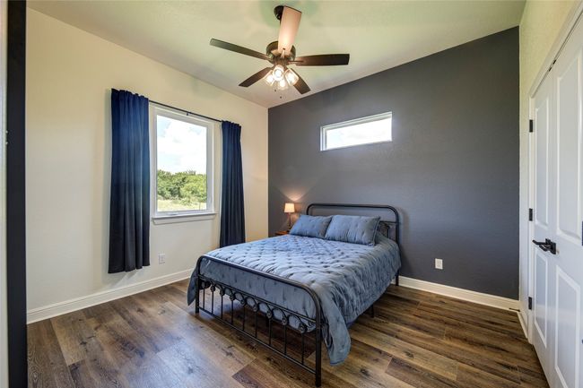 Bedroom with ceiling fan and dark wood-type flooring | Image 25