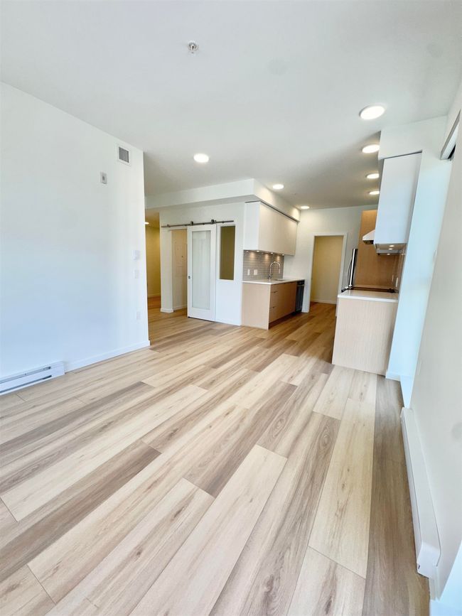 Unfurnished living room featuring recessed lighting, light wood finished floors, visible vents, and a sink | Image 6