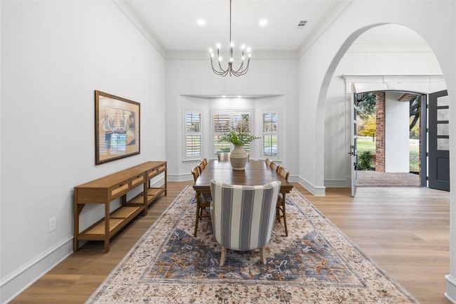 Dining space with arched walkways, ornamental molding, light wood-style flooring, a chandelier, and recessed lighting | Image 8