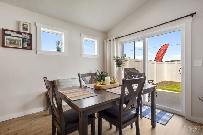 Dining room with lofted ceiling and light wood finished floors | Image 9