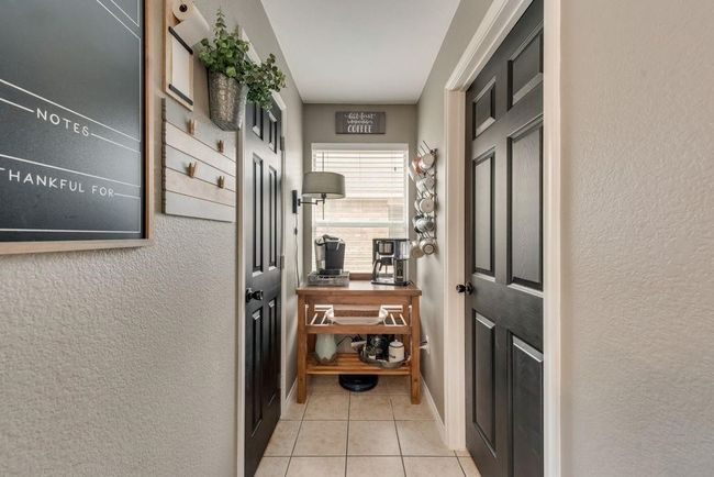 Doorway to outside with tile patterned floors and a textured wall | Image 14
