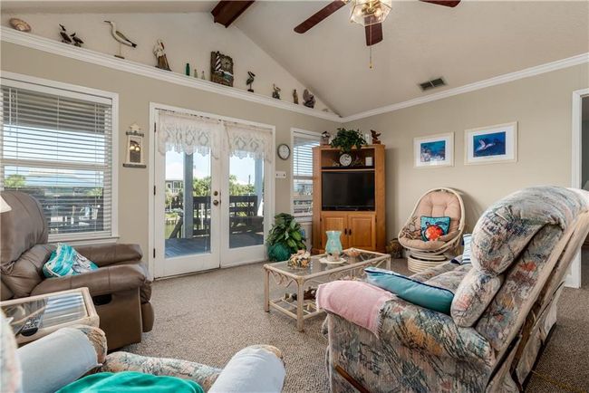 Living room featuring lofted ceiling with beams, a ceiling fan, and plenty of natural light | Image 33