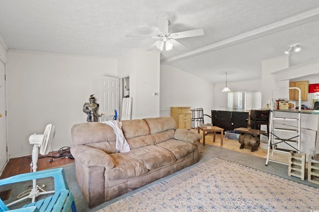 Living room featuring a ceiling fan, a textured ceiling, and vaulted ceiling | Image 19