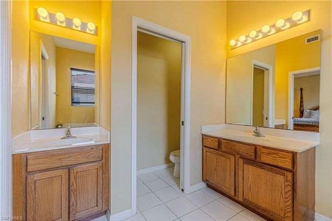 Bathroom featuring a sink, visible vents, tile patterned floors, and two vanities | Image 23