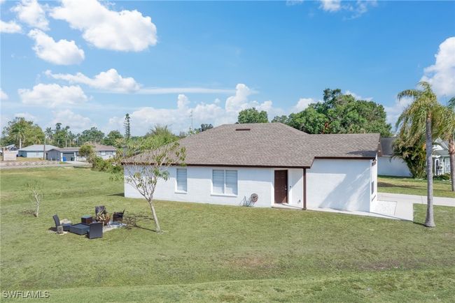 Rear view of house with a lawn and a shingled roof | Image 16