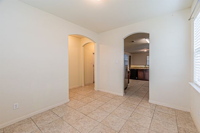 Spare room featuring light tile patterned floors, a sink, arched walkways, and plenty of natural light | Image 6
