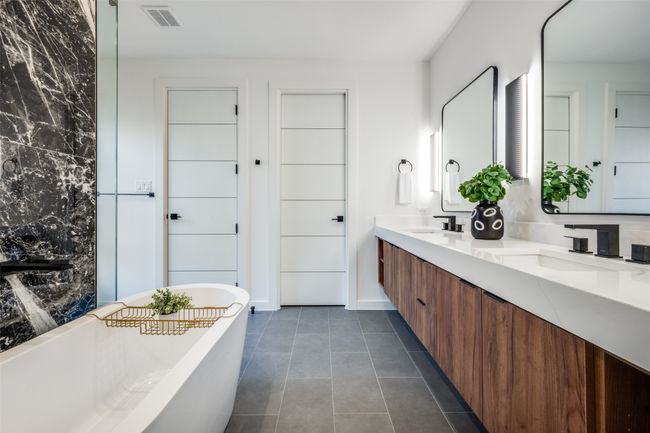 Full bathroom featuring double vanity, a soaking tub, and tile patterned floors | Image 13