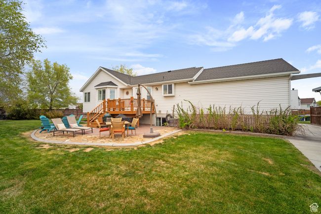 Rear view of property featuring a patio, a wooden deck, stairway, a yard, and fence | Image 31