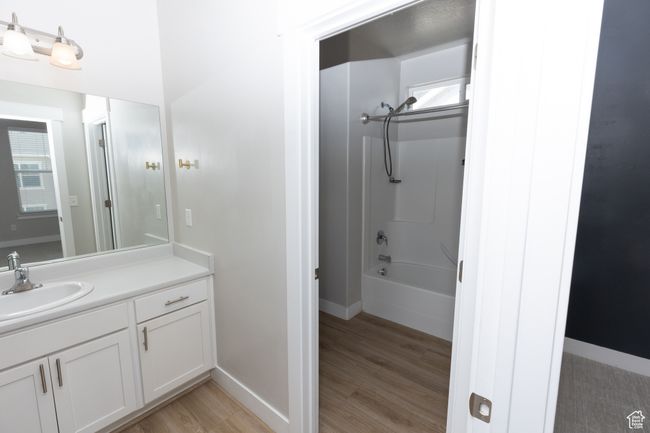 Bathroom featuring vanity, wood finished floors, shower / bathtub combination, and baseboards | Image 13