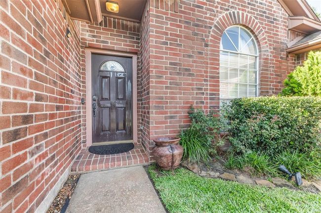 Inviting front entrance with all bricks and lush landscaping. | Image 4