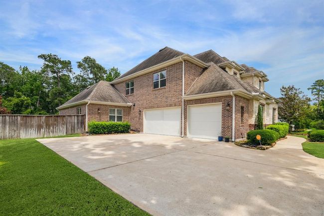Garage includes generator outlet, epoxied floor, & air conditioning. | Image 48