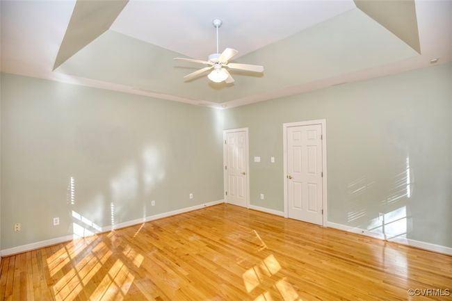 Unfurnished room with ceiling fan, baseboards, light wood finished floors, and a raised ceiling | Image 23