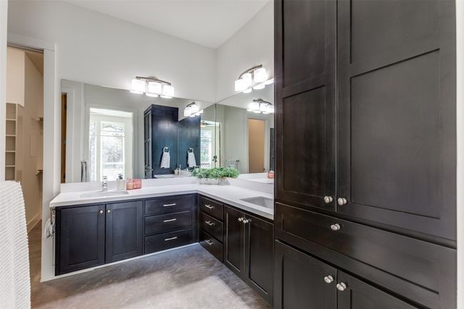 Full bath featuring double vanity, a spacious closet, concrete floors, and a sink | Image 16