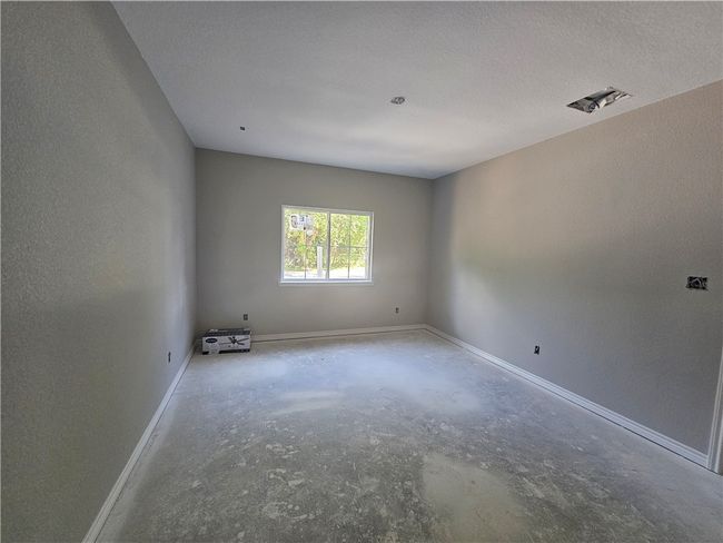 Unfurnished room featuring unfinished concrete flooring and baseboards | Image 10