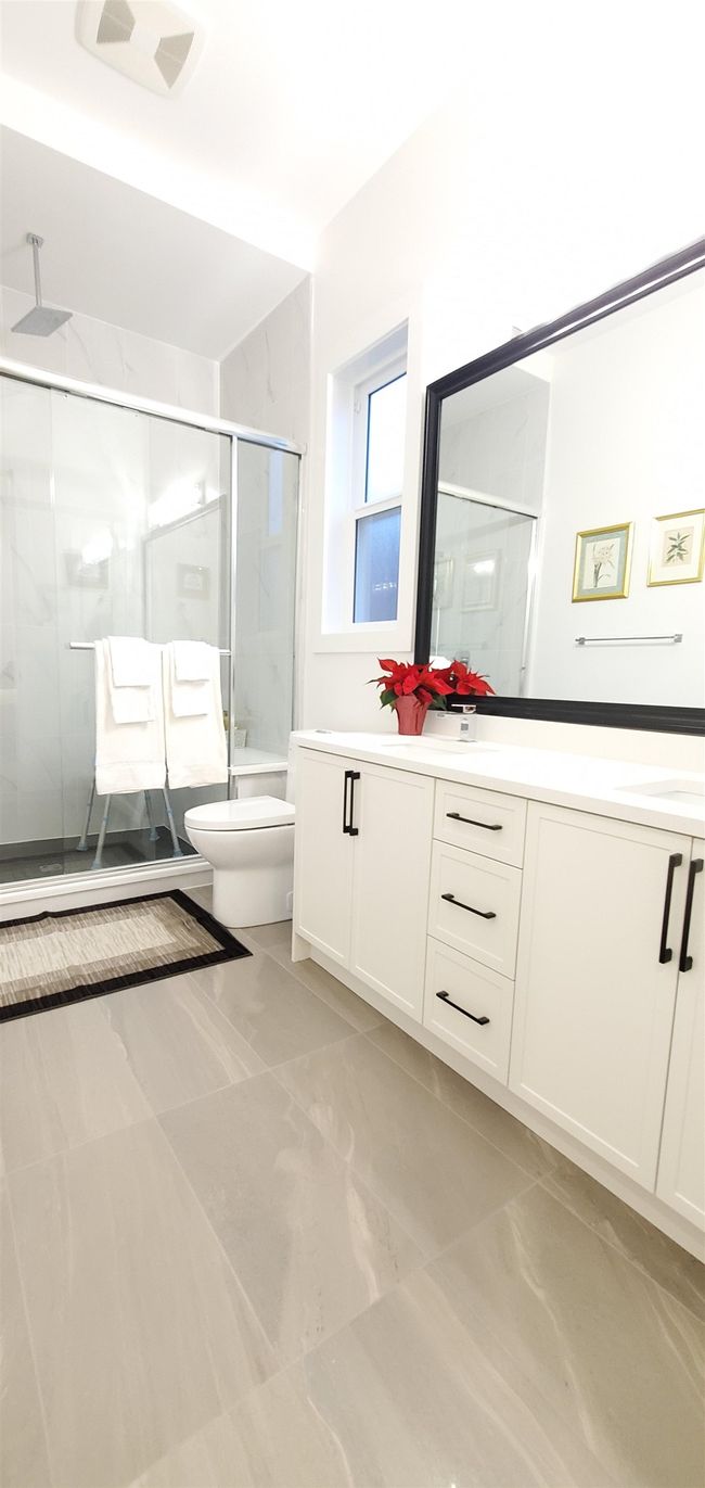Bathroom featuring vanity, a shower stall, toilet, and visible vents | Image 13