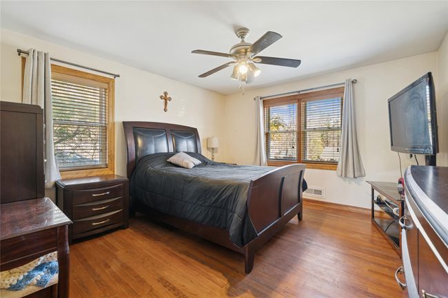 Bedroom featuring multiple windows, wood finished floors, and visible vents | Image 34
