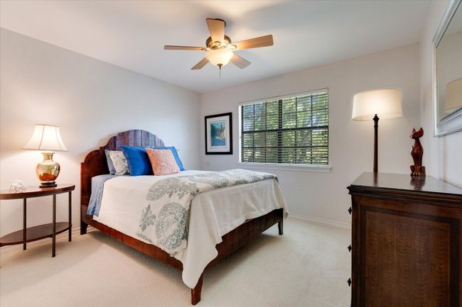Bedroom featuring light colored carpet, baseboards, and a ceiling fan | Image 25