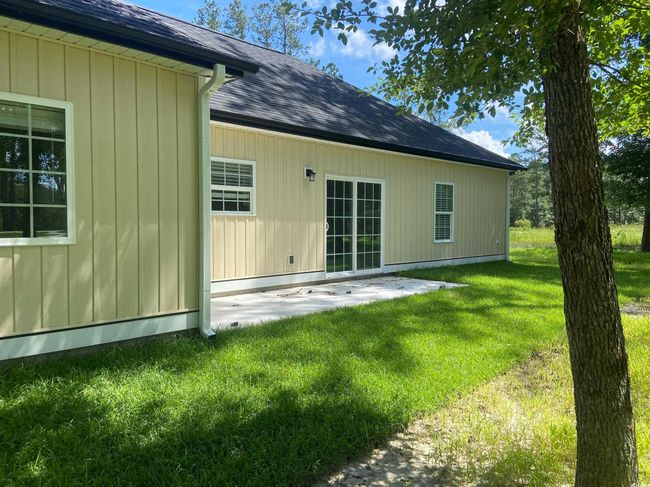 Back of property featuring a lawn, roof with shingles, and a patio | Image 6
