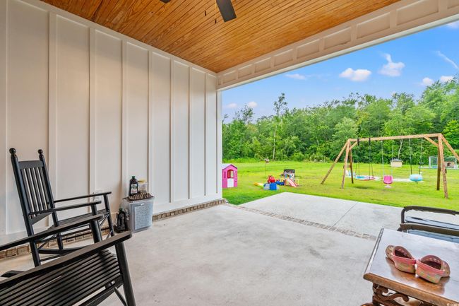 View of patio with a playground and a ceiling fan | Image 37