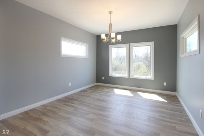 spare room with a chandelier, baseboards, and light wood-style flooring | Image 4