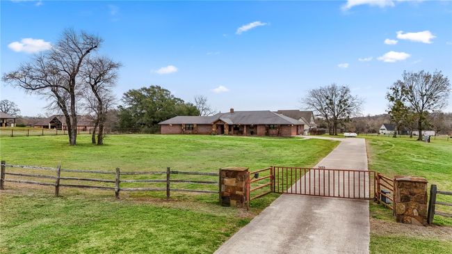View of front of home featuring a front yard, a gate, fence, a rural view, and driveway | Image 6
