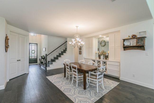 Dining area with stairs, dark wood-type flooring, a chandelier, and recessed lighting | Image 13