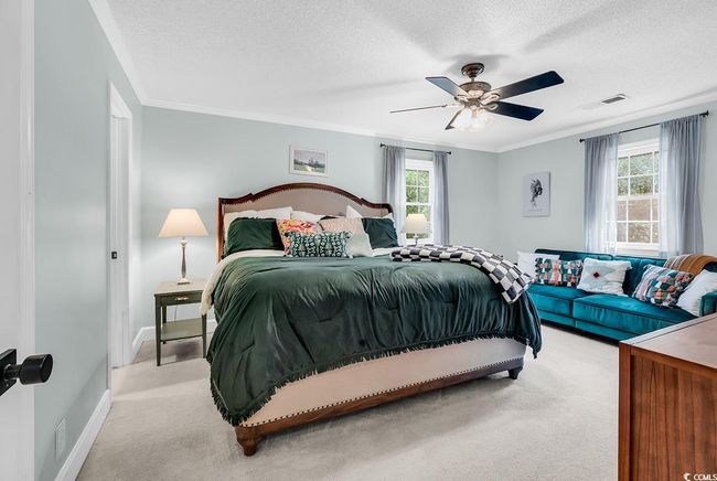 Bedroom featuring carpet flooring, a textured ceiling, crown molding, and ceiling fan | Image 17