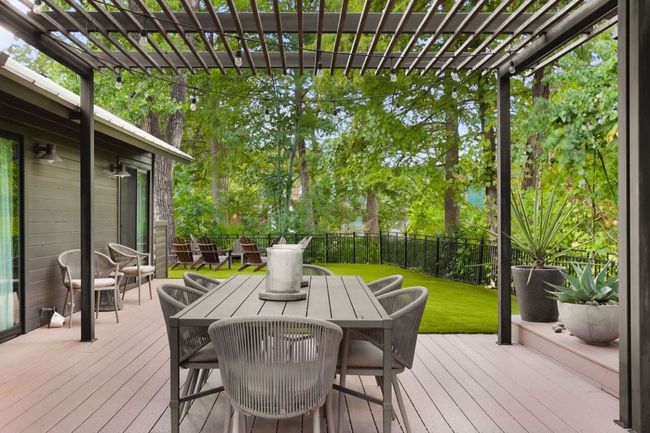 Wooden deck with a fenced backyard, a lawn, outdoor dining area, and a pergola | Image 29