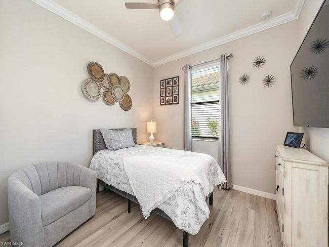 Bedroom featuring ceiling fan, ornamental molding, light wood-style flooring, and baseboards | Image 9