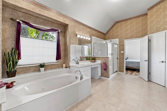 A luxurious whirlpool tub invites you to relax, while the separate vanities with ample counter space adds both functionality and elegance | Image 22