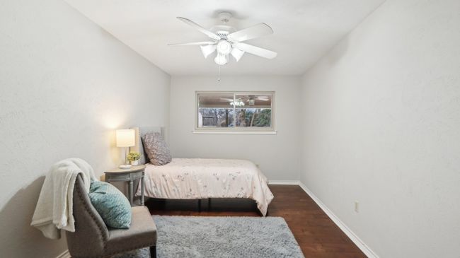 Bedroom with baseboards, dark wood-style flooring, and ceiling fan | Image 16