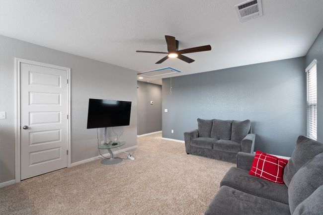 Living room with ceiling fan, attic access, and carpet | Image 18