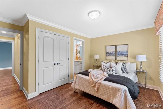 Bedroom with a closet, crown molding, wood finished floors, and ensuite bathroom | Image 31