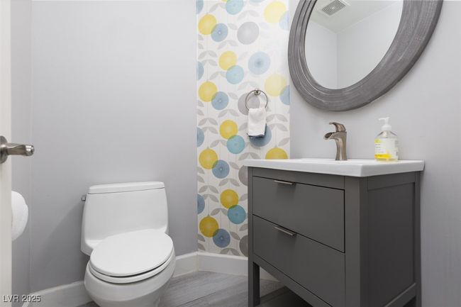 Bathroom with curtained shower, visible vents, toilet, vanity, and baseboards | Image 12