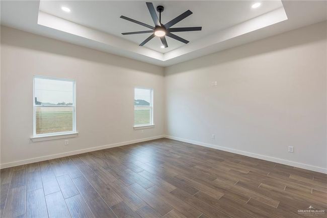 Unfurnished room with ceiling fan and a tray ceiling | Image 12