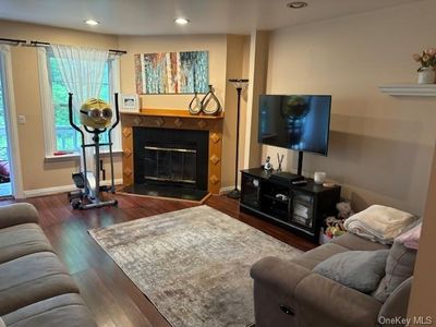 Living room featuring a tile fireplace and dark hardwood / wood-style flooring | Image 2