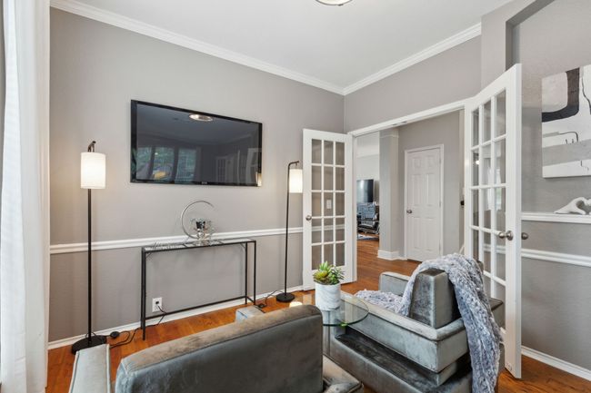 Living area with french doors, ornamental molding, wood finished floors, and baseboards | Image 12