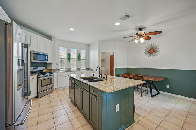 Kitchen featuring appliances with stainless steel finishes, a sink, white cabinets, a kitchen island with sink, and recessed lighting | Image 10