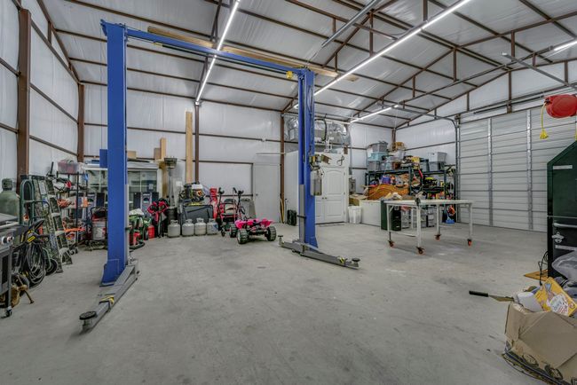 View of insulated workshop offering electricity, half bathroom and 11, 000 lb car lift. | Image 22